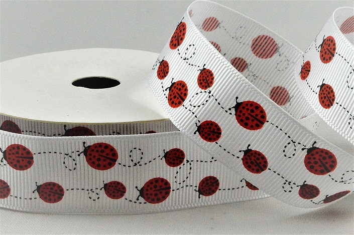 55136 - 22mm White grosgrain ribbon printed with a Swirling Lady Birds design x 10mts. 